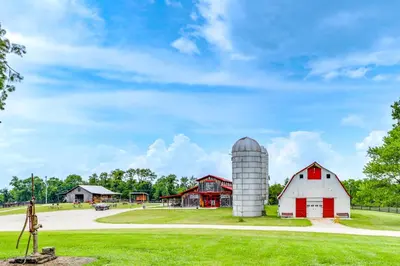 a farm with a red and white barn and a silo at Vineyard Retreat at George Vest Historical Home in Verona