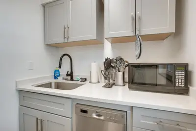 a kitchen with a sink and a microwave at Dayton Condo with Courtyard Less Than 3 to Downtown! in Dayton