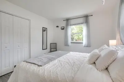a white bedroom with a bed and a window at Dayton Condo with Courtyard Less Than 3 to Downtown! in Dayton