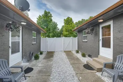 a backyard with two chairs and a fence at Dayton Condo with Courtyard Less Than 3 to Downtown! in Dayton