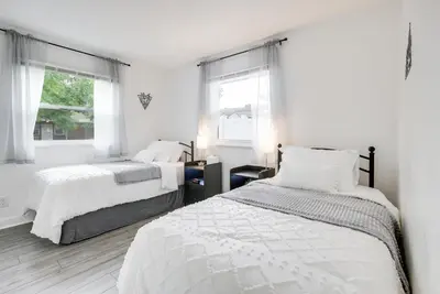 a white bedroom with two beds and two windows at Central Dayton Apt Less Than Half-Mi to UD! in Dayton
