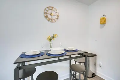 a dining table with chairs and a clock on the wall at Central Dayton Apt Less Than Half-Mi to UD! in Dayton