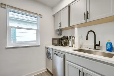 a kitchen with white cabinets and a sink and a window at Central Dayton Apt Less Than Half-Mi to UD! in Dayton
