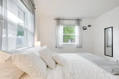 a white bedroom with a bed with pillows and a window at Central Dayton Apt Less Than Half-Mi to UD! in Dayton