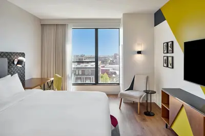 a hotel room with a bed and a desk and a window at Hotel Celare, Cincinnati Midtown, a Tribute Portfolio Hotel in Cincinnati