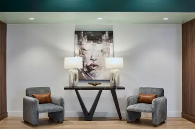 two chairs and a table in a room with a painting at Hotel Celare, Cincinnati Midtown, a Tribute Portfolio Hotel in Cincinnati