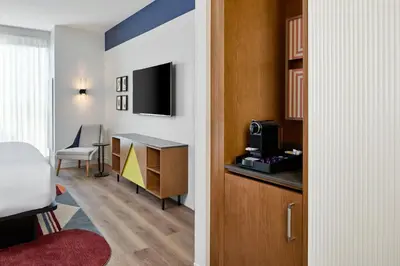a hotel room with a bed and a desk with a tv at Hotel Celare, Cincinnati Midtown, a Tribute Portfolio Hotel in Cincinnati