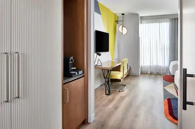 a room with a desk and a table with a television at Hotel Celare, Cincinnati Midtown, a Tribute Portfolio Hotel in Cincinnati