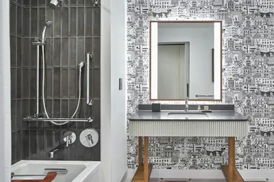 a bathroom with a sink and a mirror and a tub at Hotel Celare, Cincinnati Midtown, a Tribute Portfolio Hotel in Cincinnati