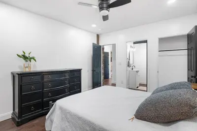 a bedroom with a bed and a dresser and a mirror at RiverSuite1 - A mesmerizing river and bridge view. in Russell