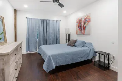 a bedroom with a bed and a painting on the wall at RiverSuite1 - A mesmerizing river and bridge view. in Russell