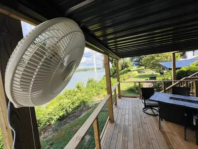 a large white fan is hanging from a porch at RiverSuite1 - A mesmerizing river and bridge view. in Russell
