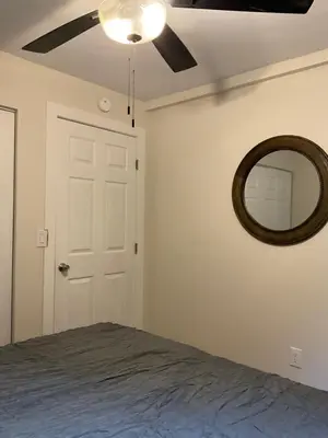 a bedroom with a ceiling fan and a mirror at Modern Farmhouse in Covington