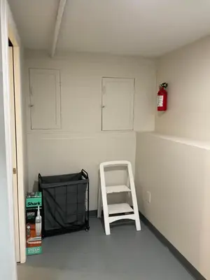 a room with a white chair and cabinets on the wall at Modern Farmhouse in Covington