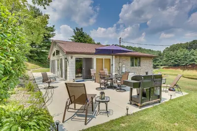 a patio with a grill and chairs and a house at Spacious Ohio Family Home on 5-Acre Property! in New Philadelphia