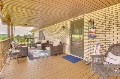 a porch with wicker furniture on a brick building at Spacious Ohio Family Home on 5-Acre Property! in New Philadelphia
