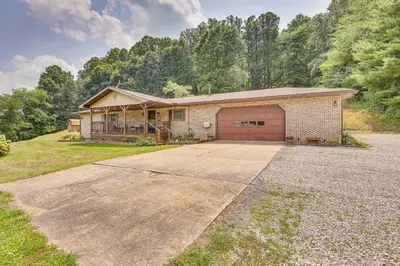 a brick house with a garage and a driveway at Spacious Ohio Family Home on 5-Acre Property! in New Philadelphia