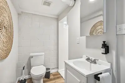 a white bathroom with a toilet and a sink at Comfort & Style - Mins to CLE Clinic - Family Friendly in South Euclid