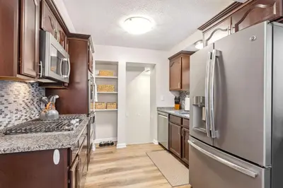 a kitchen with stainless steel appliances and wooden cabinets at Comfort & Style - Mins to CLE Clinic - Family Friendly in South Euclid