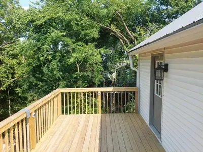 a wooden deck next to a house with trees at 5BR Home - Pets Allowed by ARK Experience in Williamstown