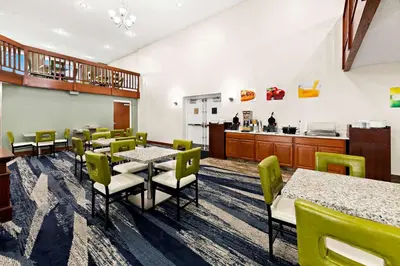 a dining room with tables and chairs and a kitchen at Suburban Studios Mason Near Kings Island in Mason