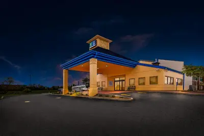 a large building with a clock tower in a parking lot at Suburban Studios Mason Near Kings Island in Mason
