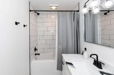 a white bathroom with a sink and a shower at Inn At Fulton Boutique Hotel in Sandusky