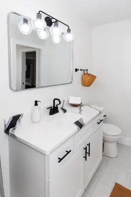 a white bathroom with a sink and a mirror at Inn At Fulton Boutique Hotel in Sandusky