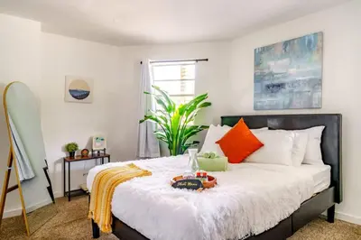 a bedroom with a bed with orange and white pillows at Jungle House Luxury Homes - Columbus Downtown Short North - Steps to Convention Center & Nationwide Arena - Sleeps up to 6 - Free Parking - Over 5,800 Five Stars in Columbus
