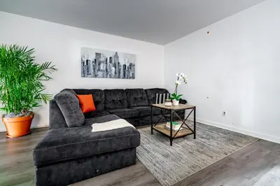 a living room with a black couch and a table at Jungle House Luxury Homes - Columbus Downtown Short North - Steps to Convention Center & Nationwide Arena - Sleeps up to 6 - Free Parking - Over 5,800 Five Stars in Columbus