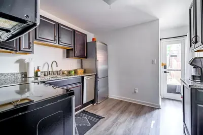 a kitchen with stainless steel appliances and wooden floors at Jungle House Luxury Homes - Columbus Downtown Short North - Steps to Convention Center & Nationwide Arena - Sleeps up to 6 - Free Parking - Over 5,800 Five Stars in Columbus