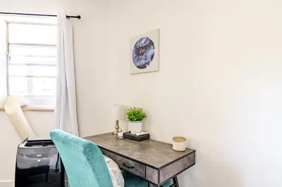 a table and a chair in a room with a window at Jungle House Luxury Homes - Columbus Downtown Short North - Steps to Convention Center & Nationwide Arena - Sleeps up to 6 - Free Parking - Over 5,800 Five Stars in Columbus
