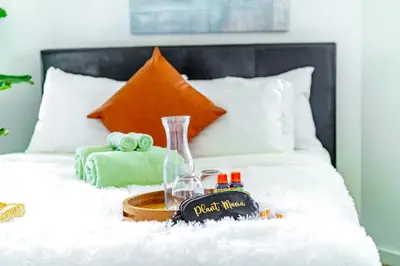 a tray with a clock on a bed at Jungle House Luxury Homes - Columbus Downtown Short North - Steps to Convention Center & Nationwide Arena - Sleeps up to 6 - Free Parking - Over 5,800 Five Stars in Columbus