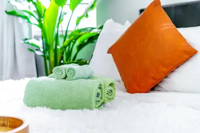 a pile of towels sitting on top of a bed at Jungle House Luxury Homes - Columbus Downtown Short North - Steps to Convention Center & Nationwide Arena - Sleeps up to 6 - Free Parking - Over 5,800 Five Stars in Columbus