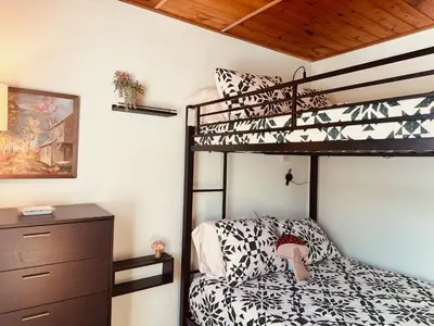 a bedroom with two bunk beds and a dresser at Little Loch home in Burton