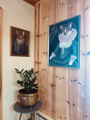 a painting of two cats on a wall with a plant at Little Loch home in Burton