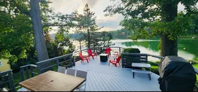 a deck with a table and chairs and a lake at Little Loch home in Burton