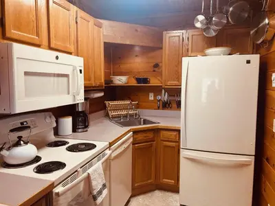 a kitchen with wooden cabinets and a white refrigerator at Little Loch home in Burton