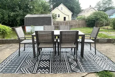 a dining table and chairs on a rug on a patio at Cozy home in Akron in Akron