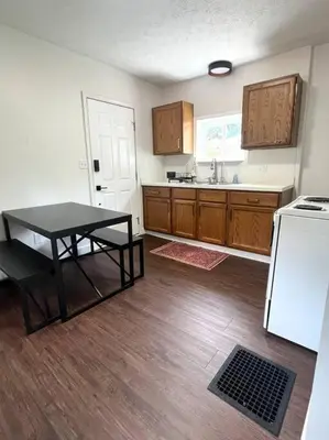 a kitchen with a table and a sink and a refrigerator at Cozy home in Akron in Akron