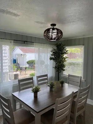 a dining room table with chairs and a light fixture at Captains Cove in Port Clinton