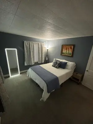 a bedroom with a bed with a blue wall at Captains Cove in Port Clinton