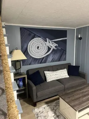 a living room with a couch and a painting of a rope at Captains Cove in Port Clinton