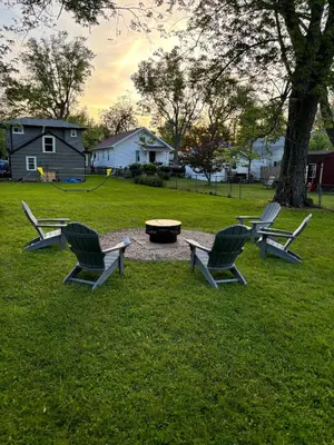 three chairs sitting in a yard with a fire pit at Captains Cove in Port Clinton