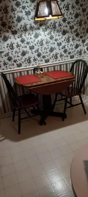 a table and two chairs sitting next to a wall with flowers at Comfy Room in Huntington