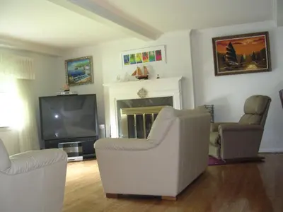 a living room with two chairs and a television at Comfy Room in Huntington