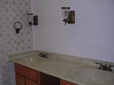 a bathroom with a sink and two lights on the wall at Comfy Room in Huntington