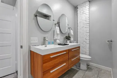 a bathroom with a sink and a toilet and two mirrors at The Columbus Adventure in Columbus
