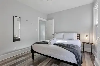 a white bedroom with a large bed with a stuffed animal on it at The Columbus Adventure in Columbus