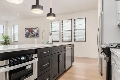 a kitchen with black cabinets and white counter tops at Luxury Escape 4BR 3 bath Oasis in Historic Old Town in Columbus
